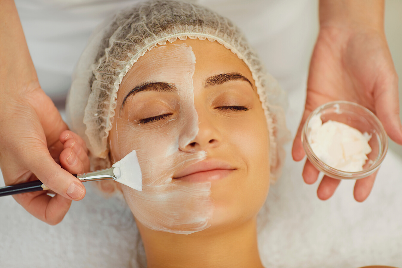 Hands of Cosmetology Specialist Applying White Facial Mask Using Brush, Making Skin Hydrated.